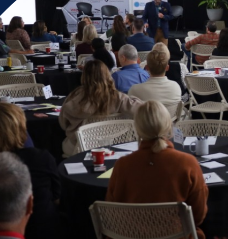 Attendees seated at tables during a previous summit session at the WKU Innovation Campus
